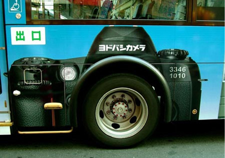 ラッピングバス広告 タイヤの一部をカメラのレンズに見立てている